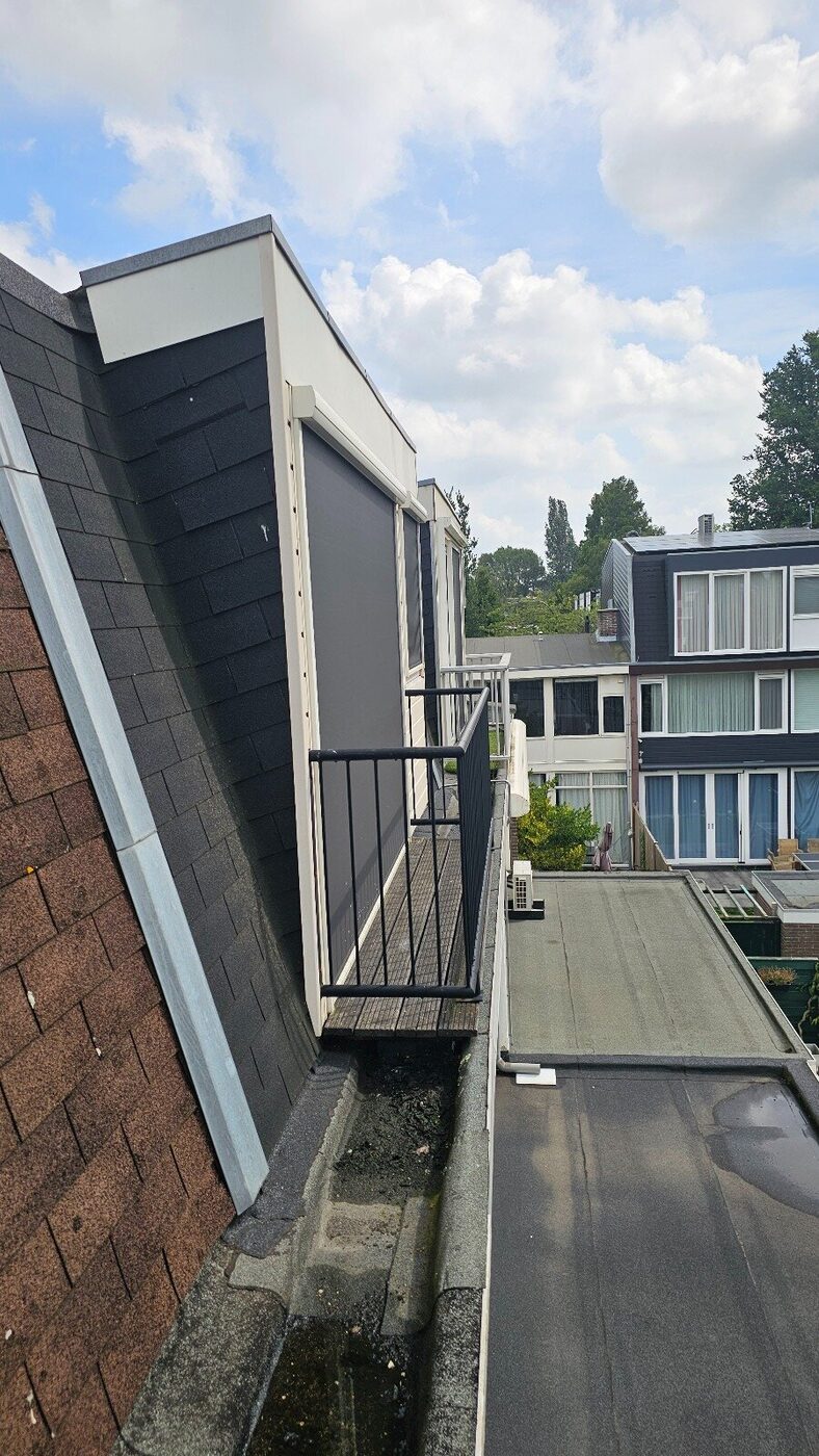 Before: the old sloping roof with a small window and balcony