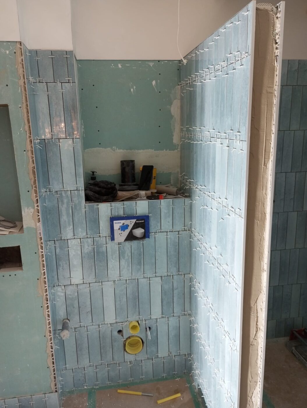 Blue tiles being laid in the new bathroom