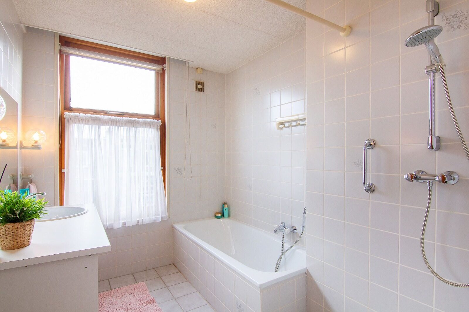 Before: the old bathroom with a tiled bath under the window