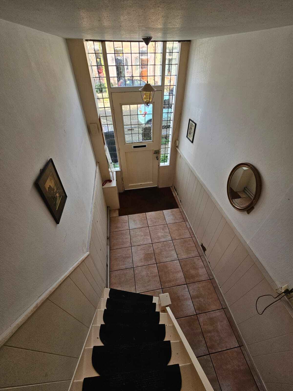 Before: the hall with floor tiles and a stair runner