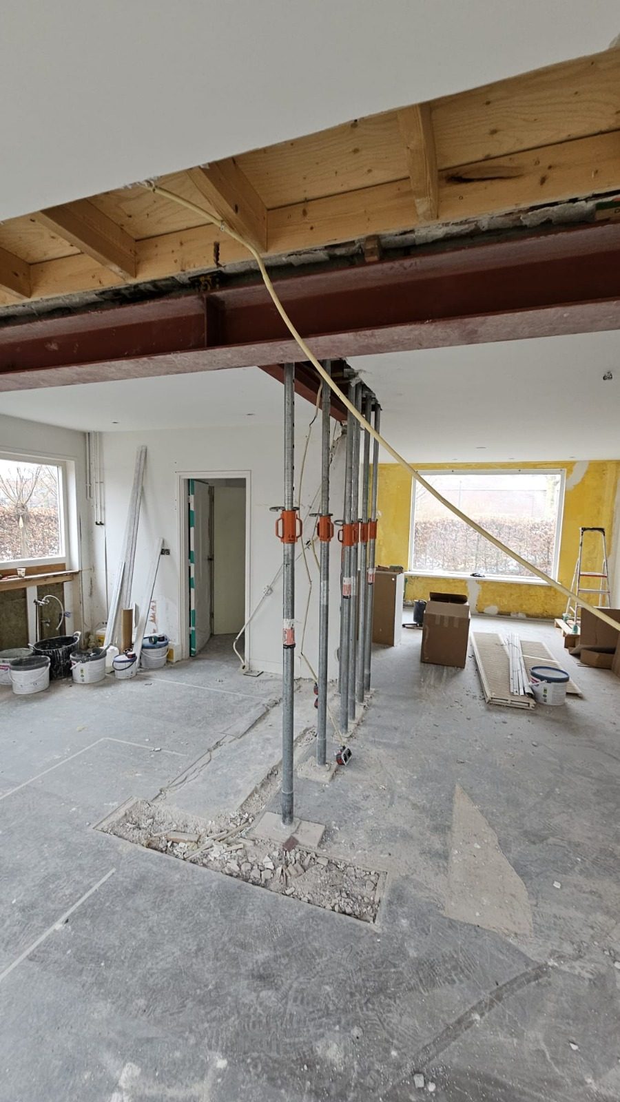 A new steel beam under the ceiling, held up by temporary props