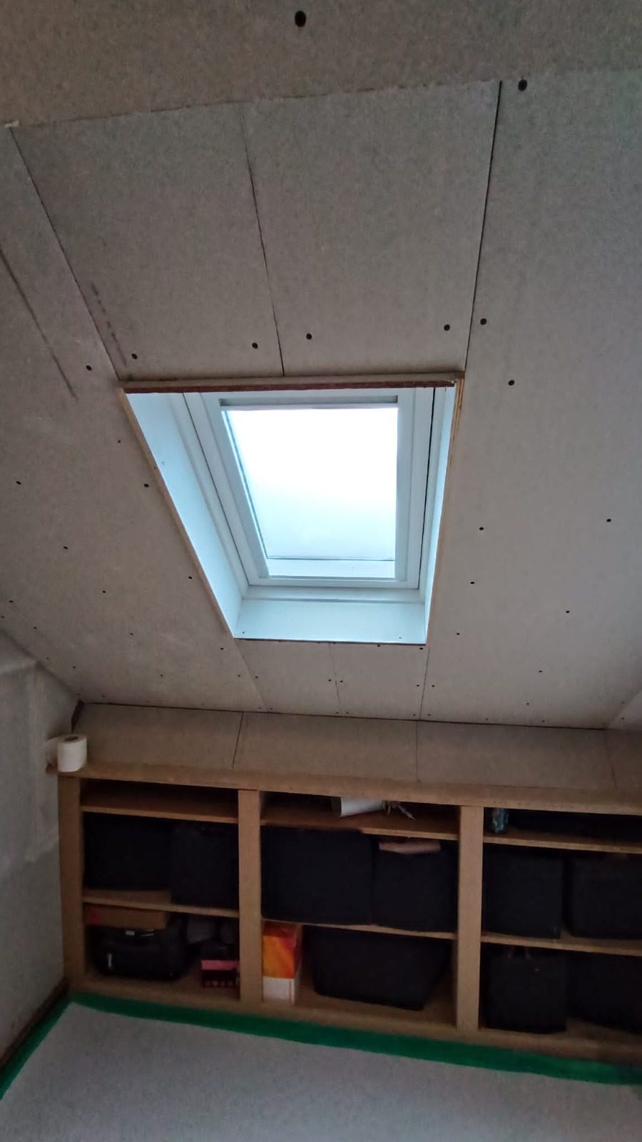 A new roof window boarded in, with shelving built into the knee wall below