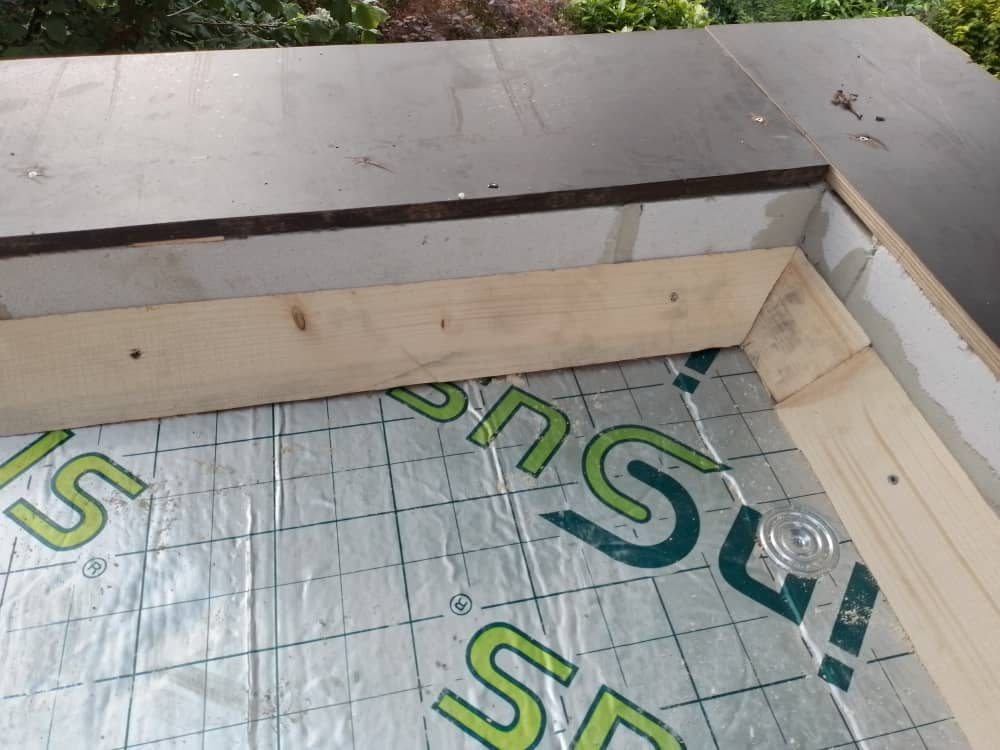 Insulation boards on the roof deck inside a timber edge
