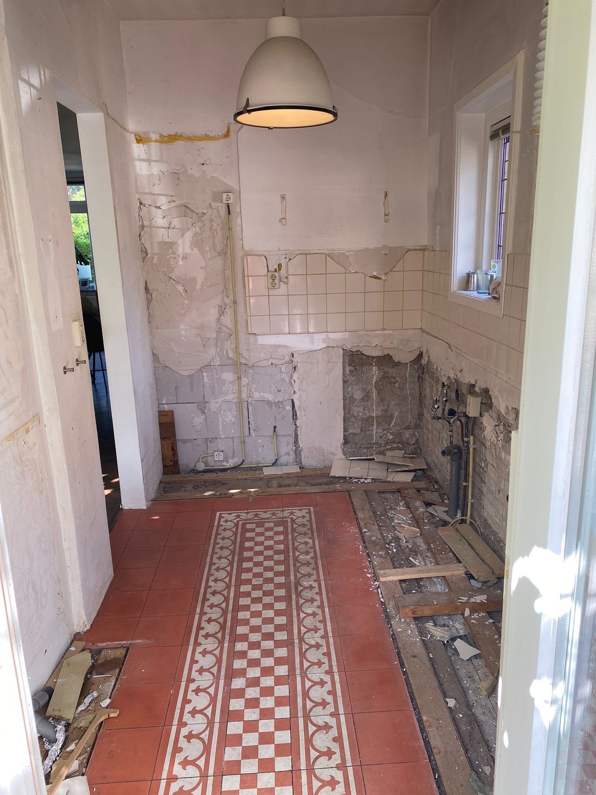 Before: a galley kitchen stripped back to the brick and the pipes
