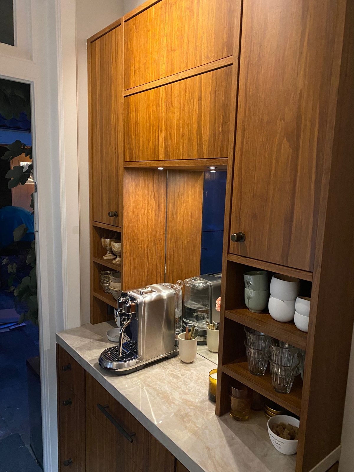 Open shelves and a coffee corner built into walnut tall units