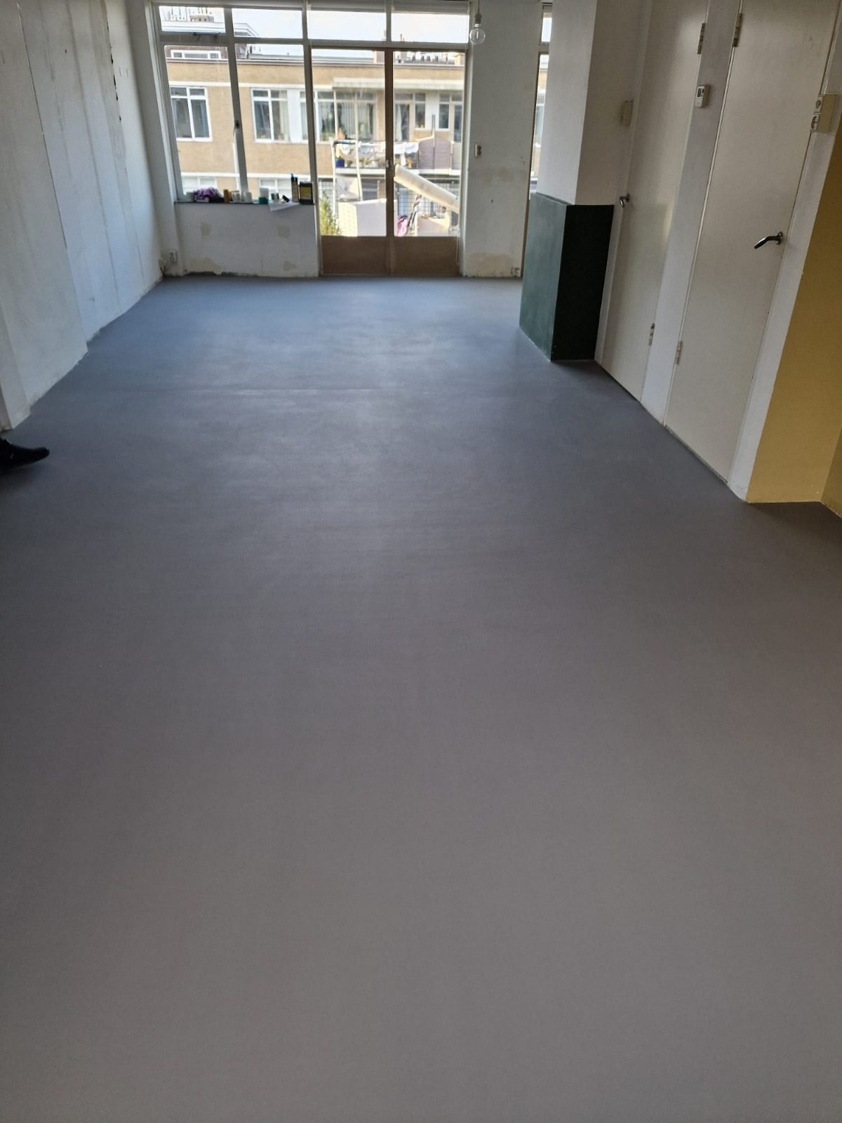 A long room with a smooth grey floor finish