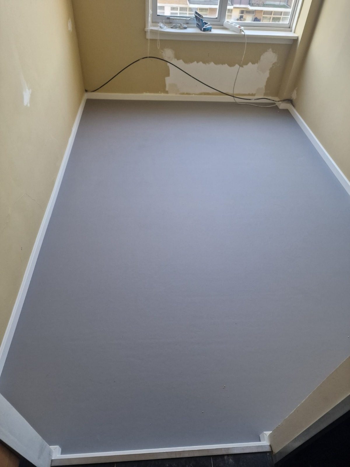 After: the same room with a smooth grey floor finish