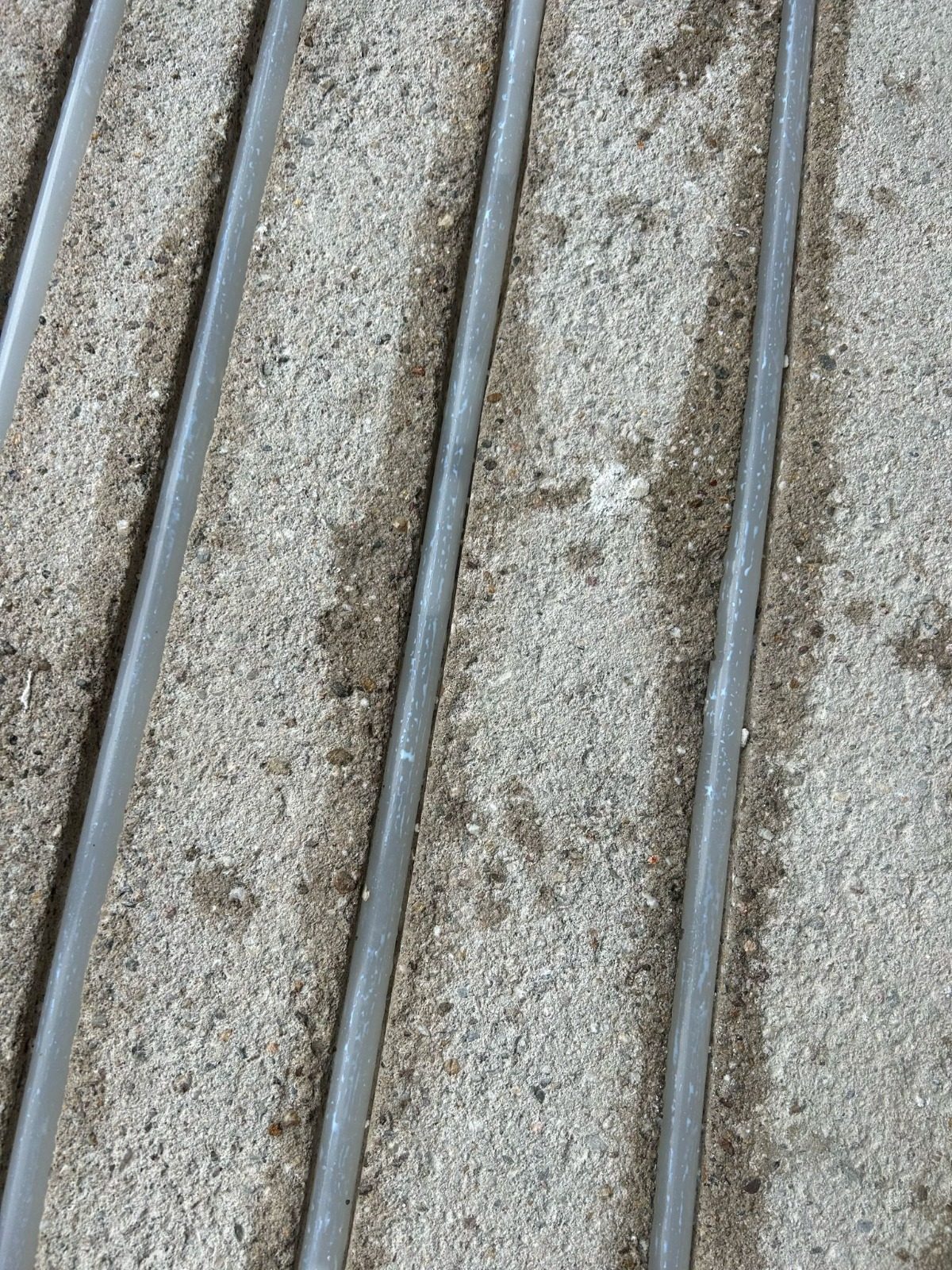 Heating pipes in channels milled into a screed floor, close up
